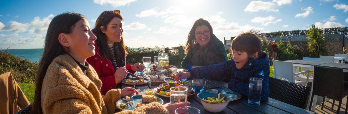 Family eating outside in the sunshine